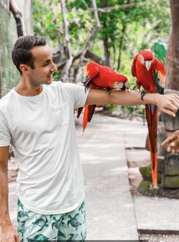 man holding macaws