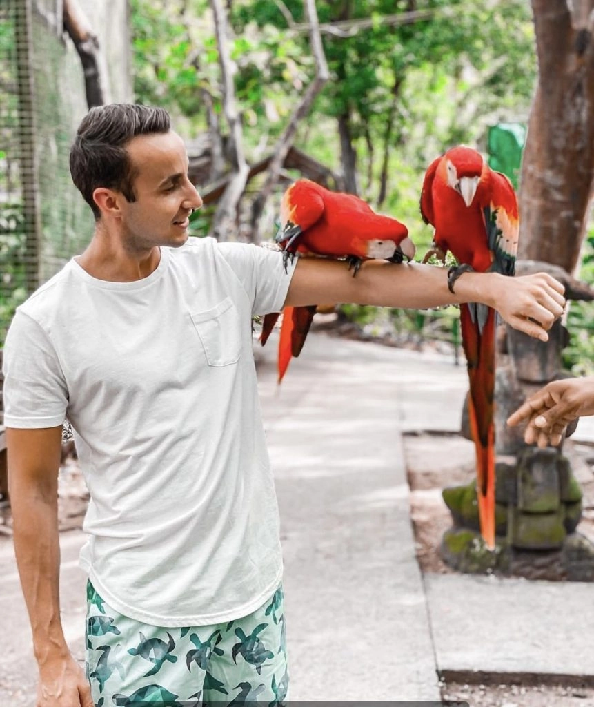 man holding macaws